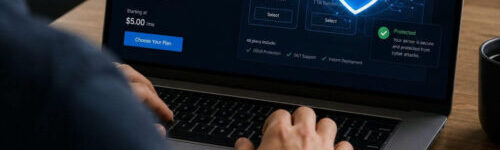 A person uses a laptop displaying a VPS hosting service webpage, featuring a large shield with a padlock icon illustrating security.