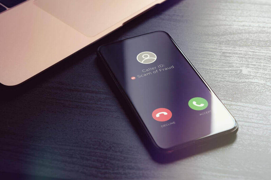 Smartphone displaying a scam or fraud caller id alert on the screen with options to accept or decline the call.