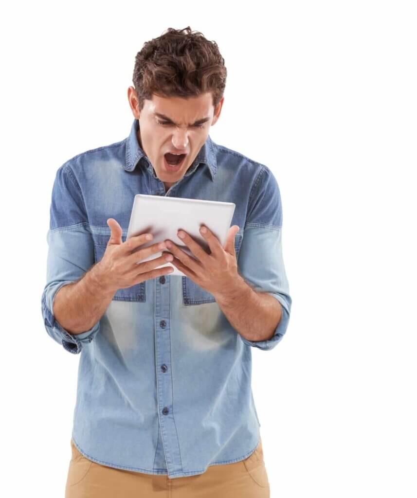 A man in a denim shirt looks at his tablet with an angry, yelling expression—perhaps frustrated by email security issues—against a white background.